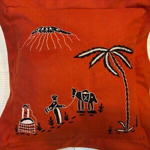 Whimsical desert scene stitched on orange wool pillow cover